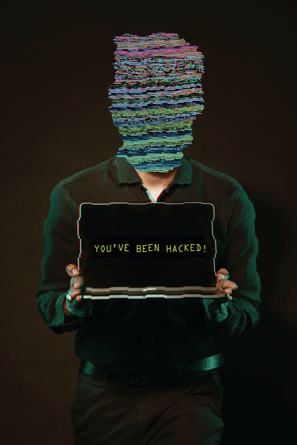 Hombre con la clara cubierta por un glitch sosteniendo una notebook que dice "You've been hacked!"